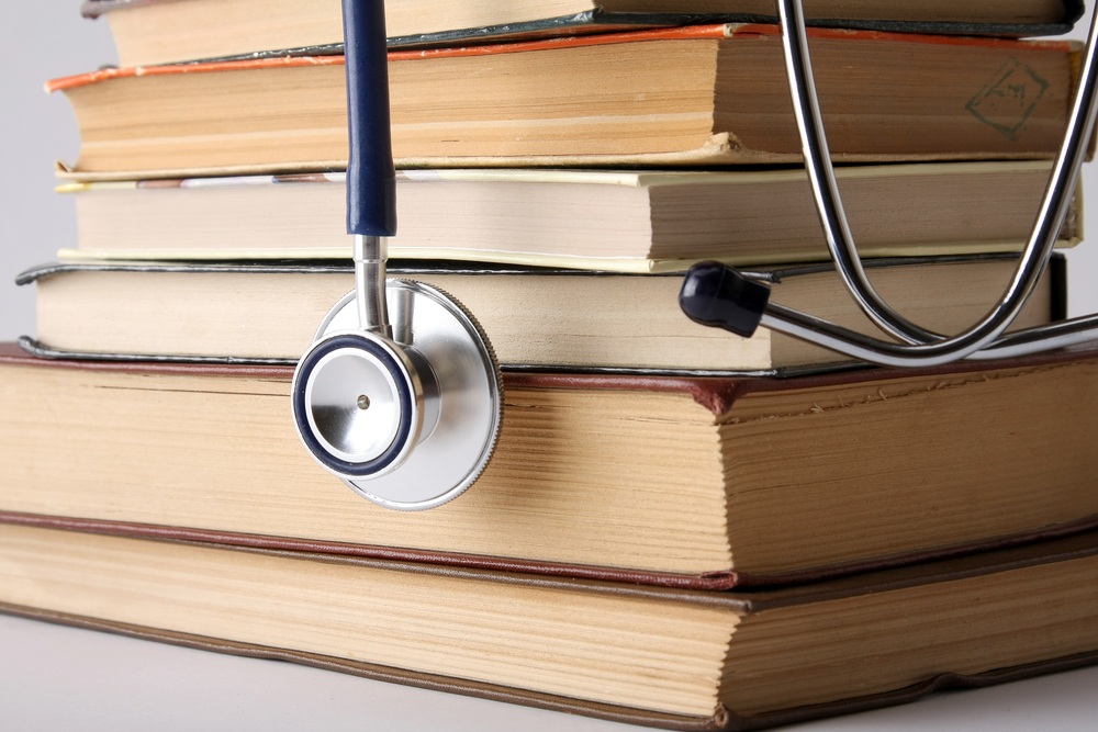 Pile of books with stethoscope on top