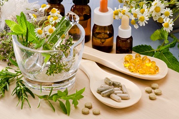 Alternative Medicine. Rosemary, mint, chamomile, thyme in a glass mortar. Essential oils and herbal supplements.