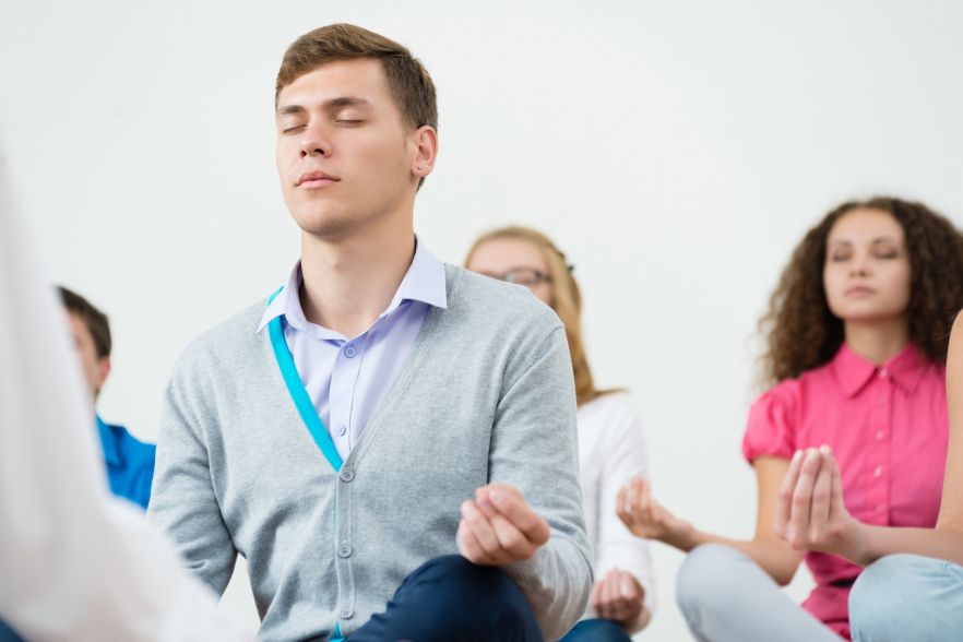 Group of adults meditating in a classroom
