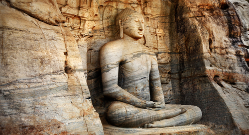 A meditation statue craving into a rock wall