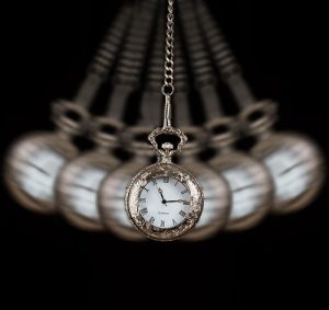 Conversational Hypnosis Photo of a pocket watch that is swinging back and forth with blurring images in the background