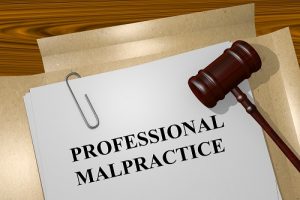 Photo of a file folder with a document laying on top that is titled Professional Malpractice with a judge's gavel laying along side of the document