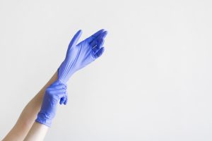 Medical professional putting on a latex glove