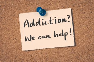 A post it note with "Addiction, We can Help!" wrote on it.