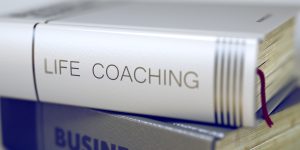 A book on its side titled "Life Coaching"