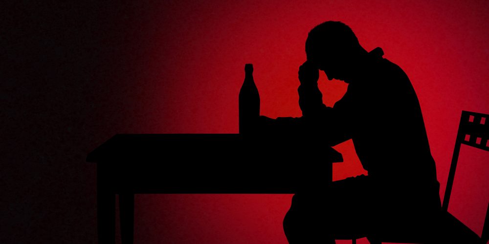 A man sitting at a table with a drink