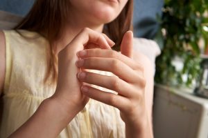 Young girl practicing EFT or emotional freedom technique - tapping on the side of the hand point, close up