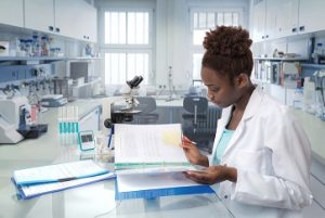 A nurse reviewing a file in a lab