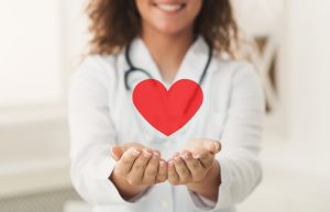 A case management nurse holding a toy heart.