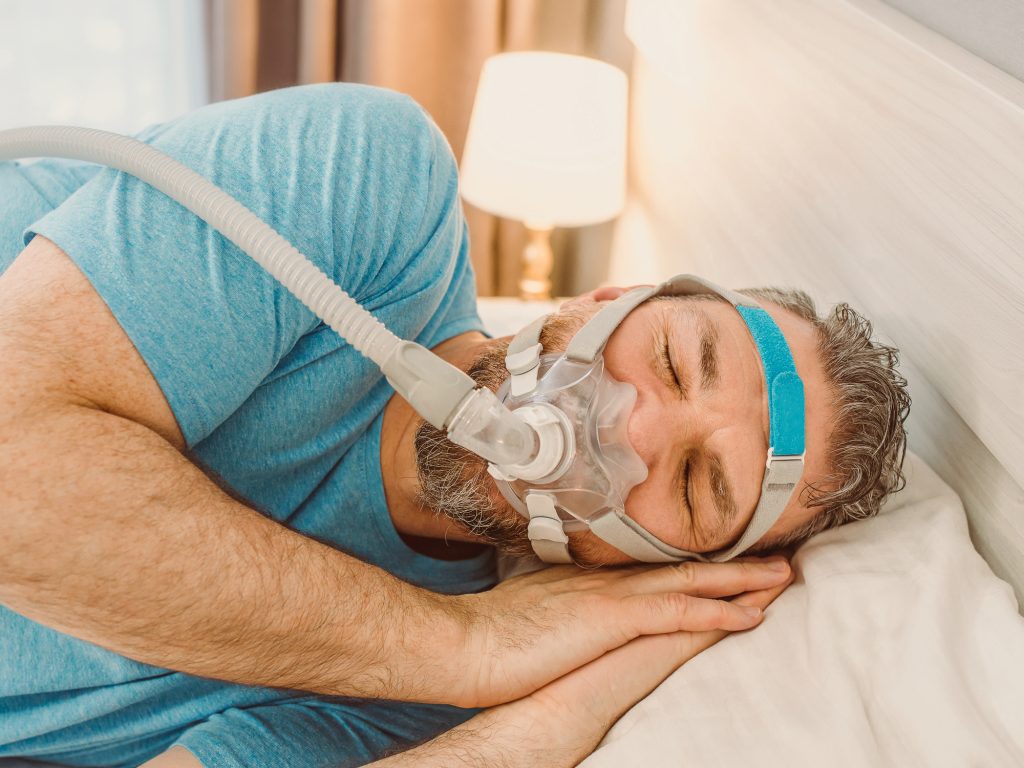 Man sleeping restfully with a CPAP machine on