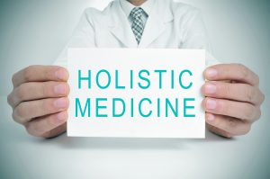 Holistic Nursing Specialist holding a sign that says Holistic Medicine