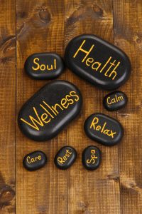 Holistic Healthcare, wellness, health, relax and other phrases wrote on stones.