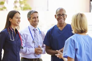 A picture of healthcare professionals and case managers discussing a patient. 