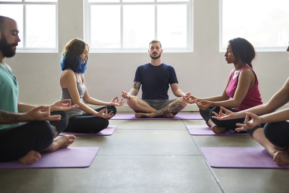 Meditation instructor running a class of men and women