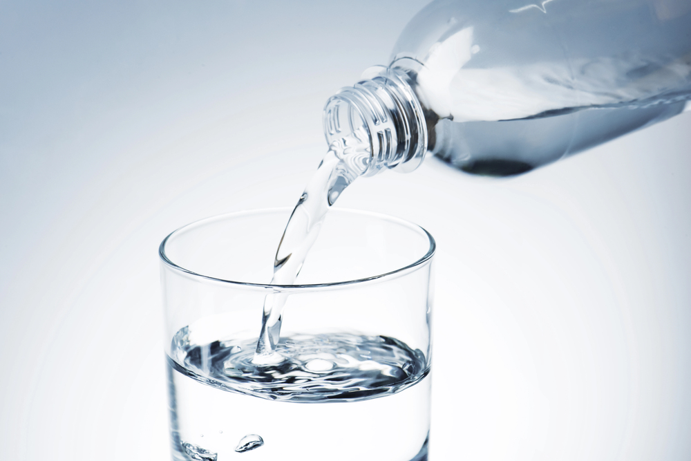 A bottle of water pouring into a glass