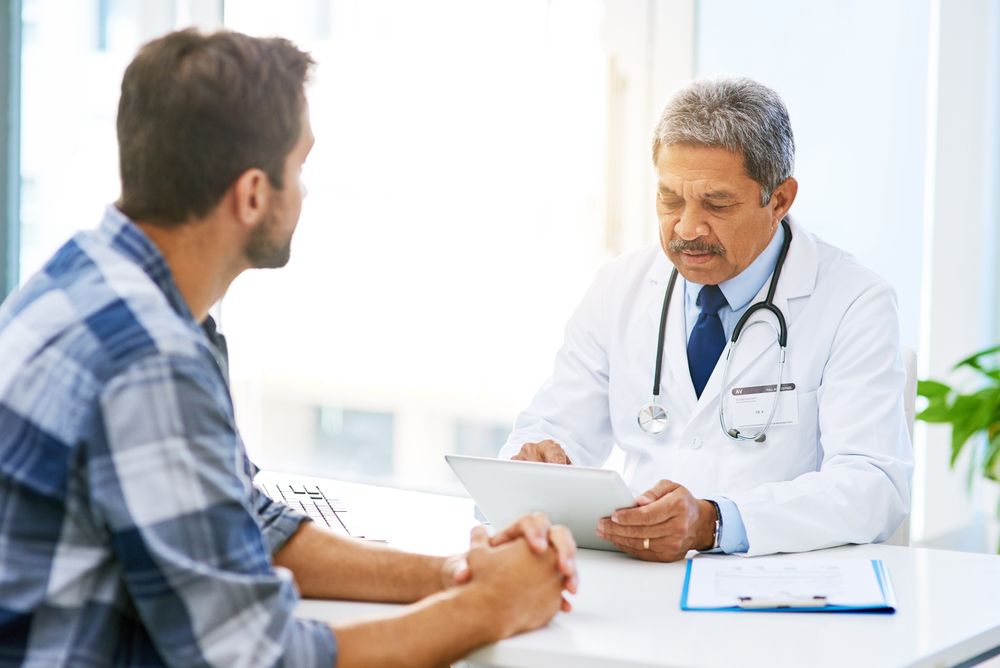  confident male doctor consulting with a patient inside of his office during the day