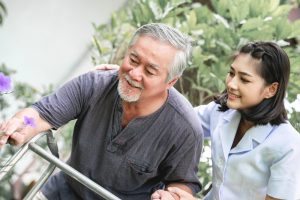 Holistic Nursing Practice: A young nurse helping an older patient.