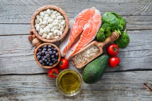 A display of Holistic Wellness friendly foods like salmon, beans, blueberries, tomatoes, etc.