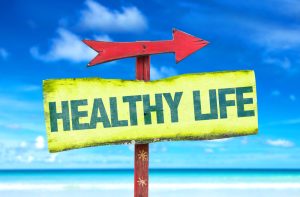 Holistic Healthy Life Sign with an arrow pointing towards a beach.