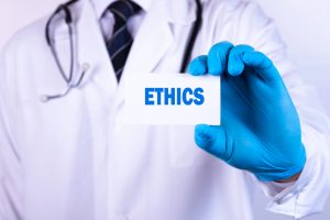 A health care ethics consultant holding up a card that says Ethics.