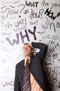 Stress Management Techniques: A business man that looks worried about questions floating around in his head.