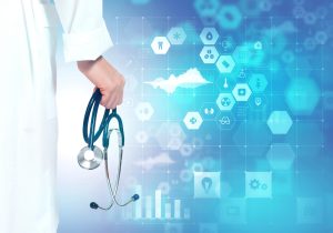 photo of the arm and hand of a health care professional in a white lab coat hold a stethoscope and a soft blue background with many light blue icons from a computer screen