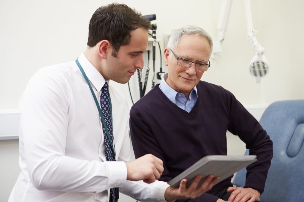 doctor showing a senior patient a test result on a tablet 