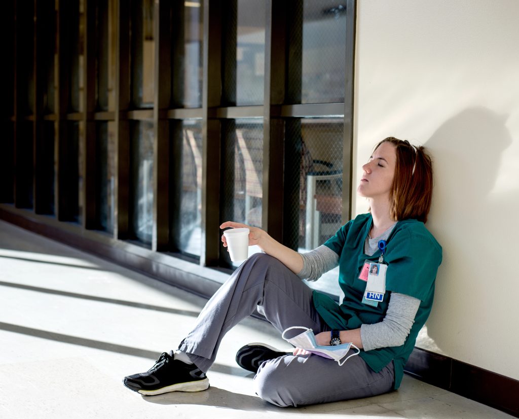 Exhausted Nurse sitting on the ground