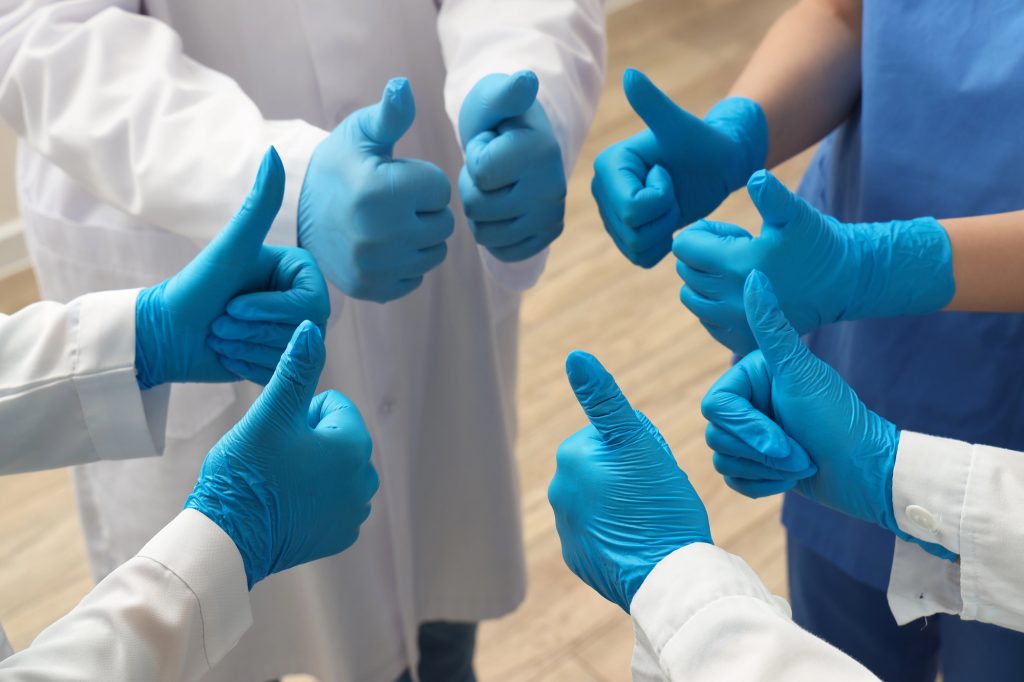 Doctors wearing gloves giving a thumbs up