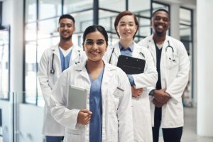 Doctors, smile and portrait in hospital standing with clipboard for health care, wellness and solidarity. Clinic, surgeons or physicians together for medical advice, teamwork or collaboration.