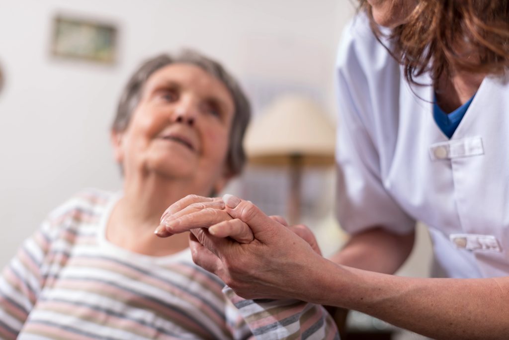 nurse examining elderly patient's hand. 