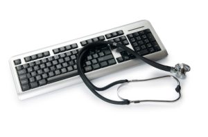 A picture of a stethoscope laying on a keyboard 