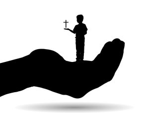 A child holding a cross while in the hand of god. 