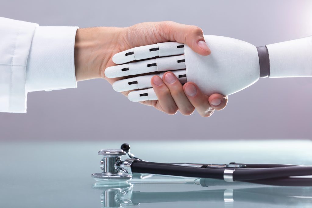 A doctor shaking the hand of a robot. 