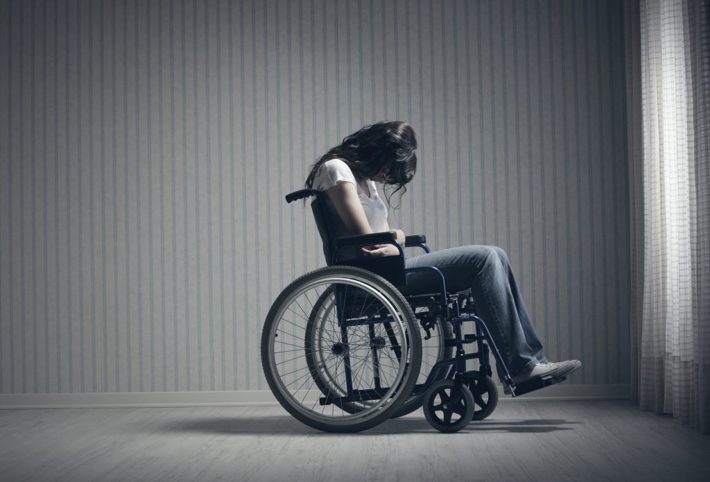 Sad woman in a wheelchair suffering with grief. 