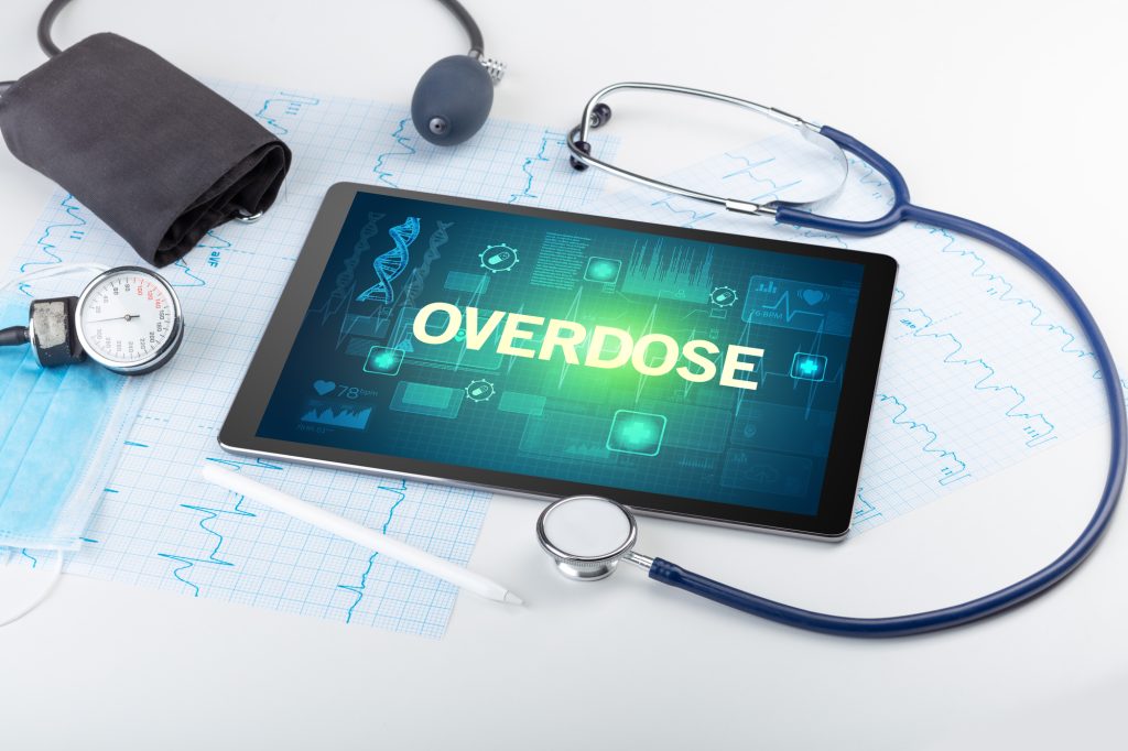 Tablet pc and medical stuff with OVERDOSE  inscription, prevention concept